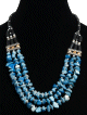 Collier ethnique artisanal trois rangs imitation quartz bleu agrémenté de perles en métal et de tubes noirs Collier ethnique artisanal trois rangs imitation quartz bleu agremente de perles en metal et de tubes noirs