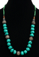 Collier ethnique artisanal imitation pierres turquoises difformes agencé de petites perles noires et vertes ainsi que de grosses perles en métal Collier ethnique artisanal imitation pierres turquoises difformes agence de petites perles noires et vertes ainsi que de grosses perles en metal